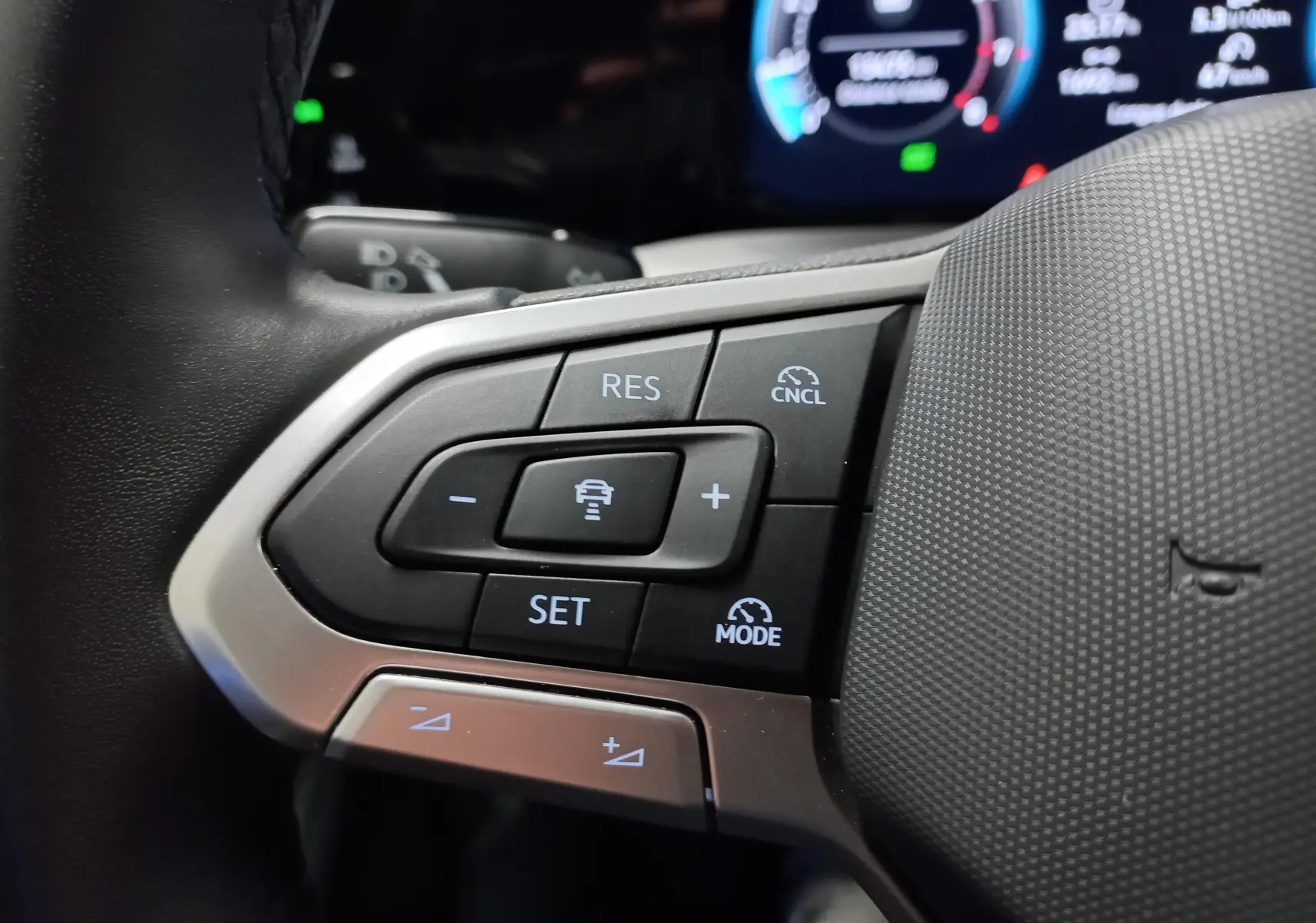 Gros plan sur les commandes de régulateur de vitesse au volant d'une Volkswagen Golf 1.5 TSI 2025.