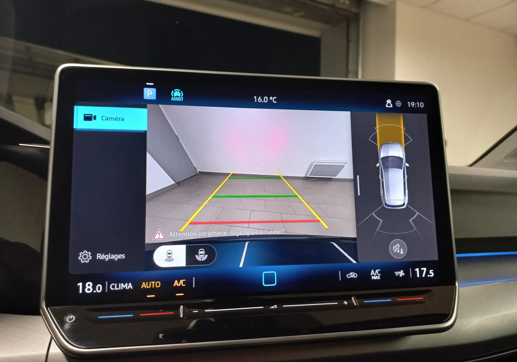 Écran central de la Volkswagen Golf 1.5 TSI bleu Anemone affichant la caméra de recul et l'aide au stationnement.