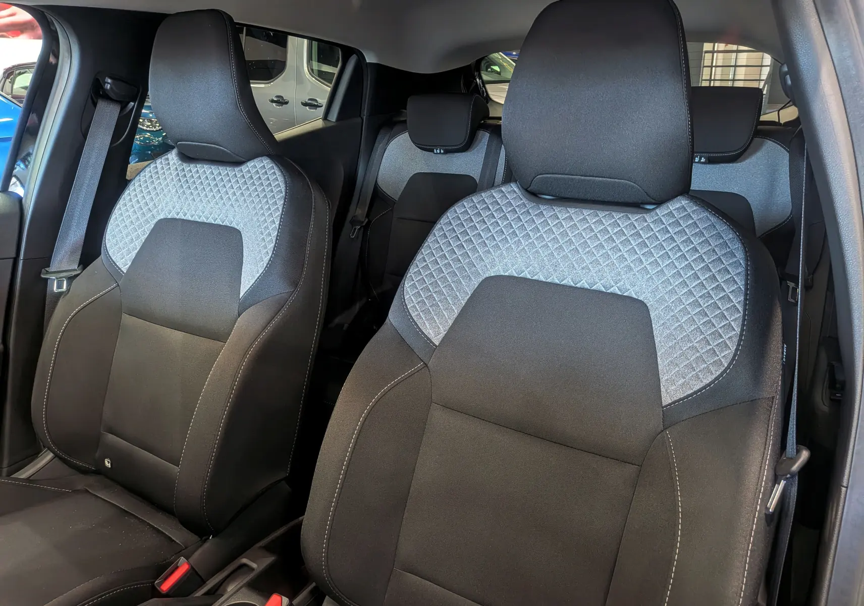 Vue intérieure sur les sièges avant en tissu noir et gris à motif losanges de la Renault Clio V 2025.