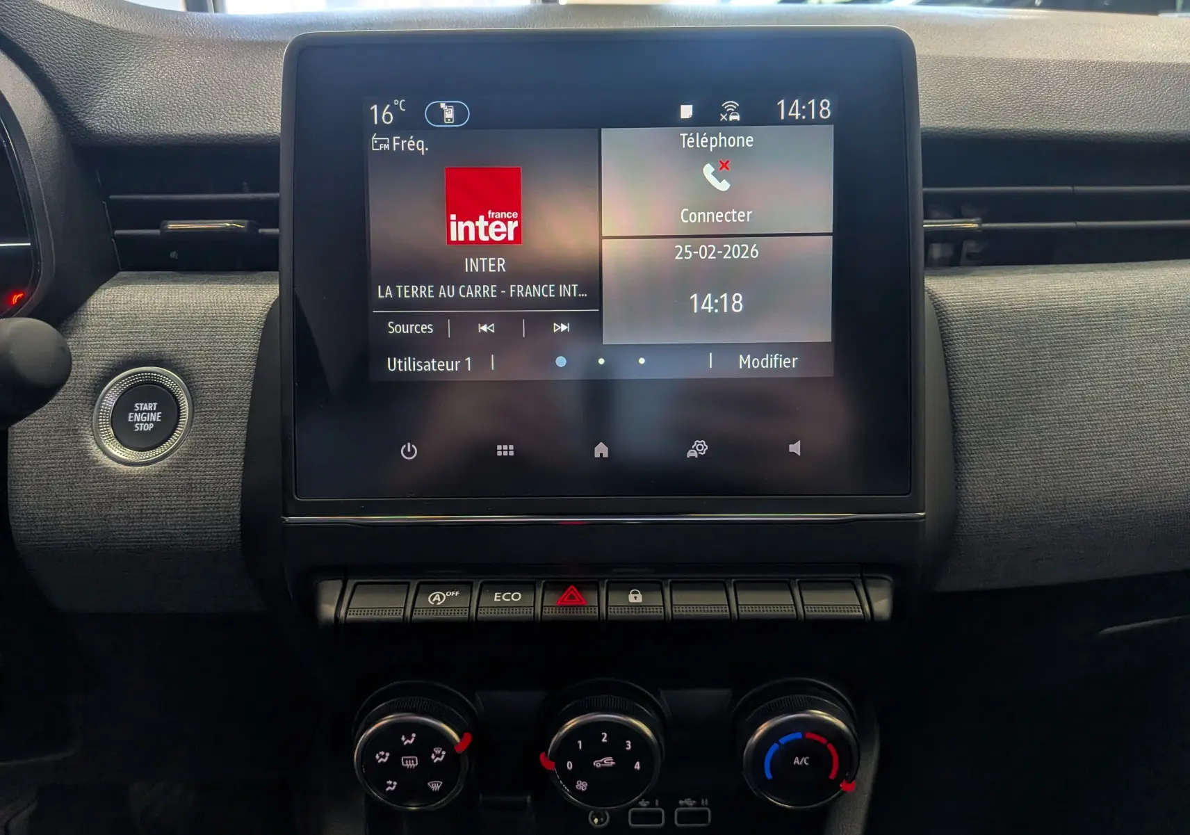 Vue rapprochée de l’écran tactile central et des commandes de climatisation du tableau de bord de la Renault Clio V noire.