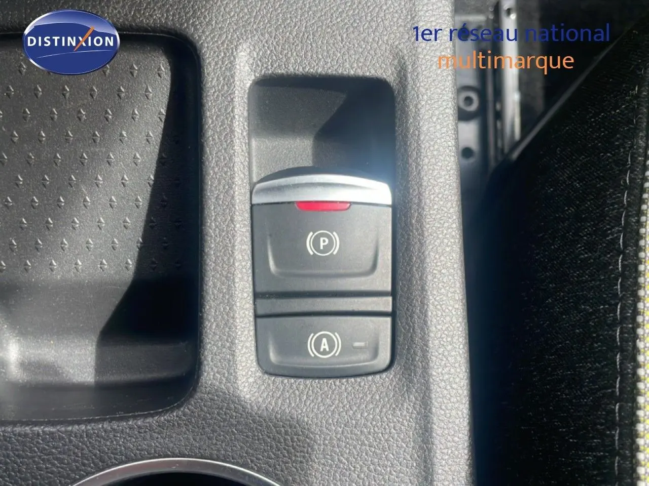 Gros plan sur les commandes de frein à main électronique et d’aide au démarrage du Renault Captur noir étoile métal avec toit gris.