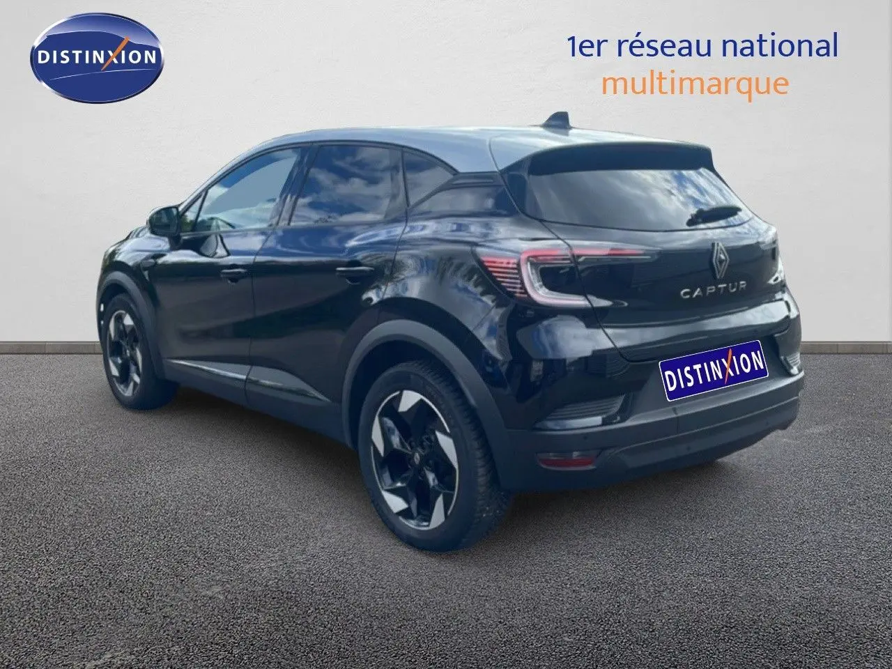Vue 3/4 arrière d'un Renault Captur noir étoile métal avec toit gris, soulignant ses feux arrière LED et jantes bicolores.