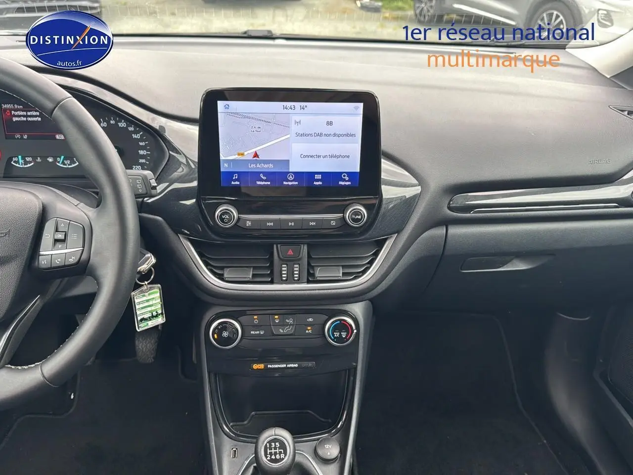 Vue intérieure frontale du tableau de bord noir du Ford Puma 2023 avec écran tactile et boîte manuelle.