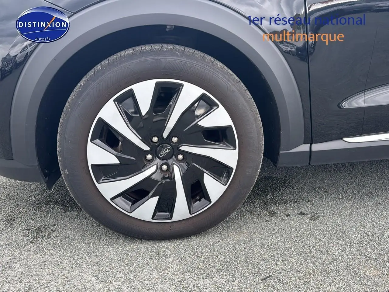 Gros plan sur la roue avant gauche noire du Ford Puma 2023 avec jante bicolore et logo Ford central.