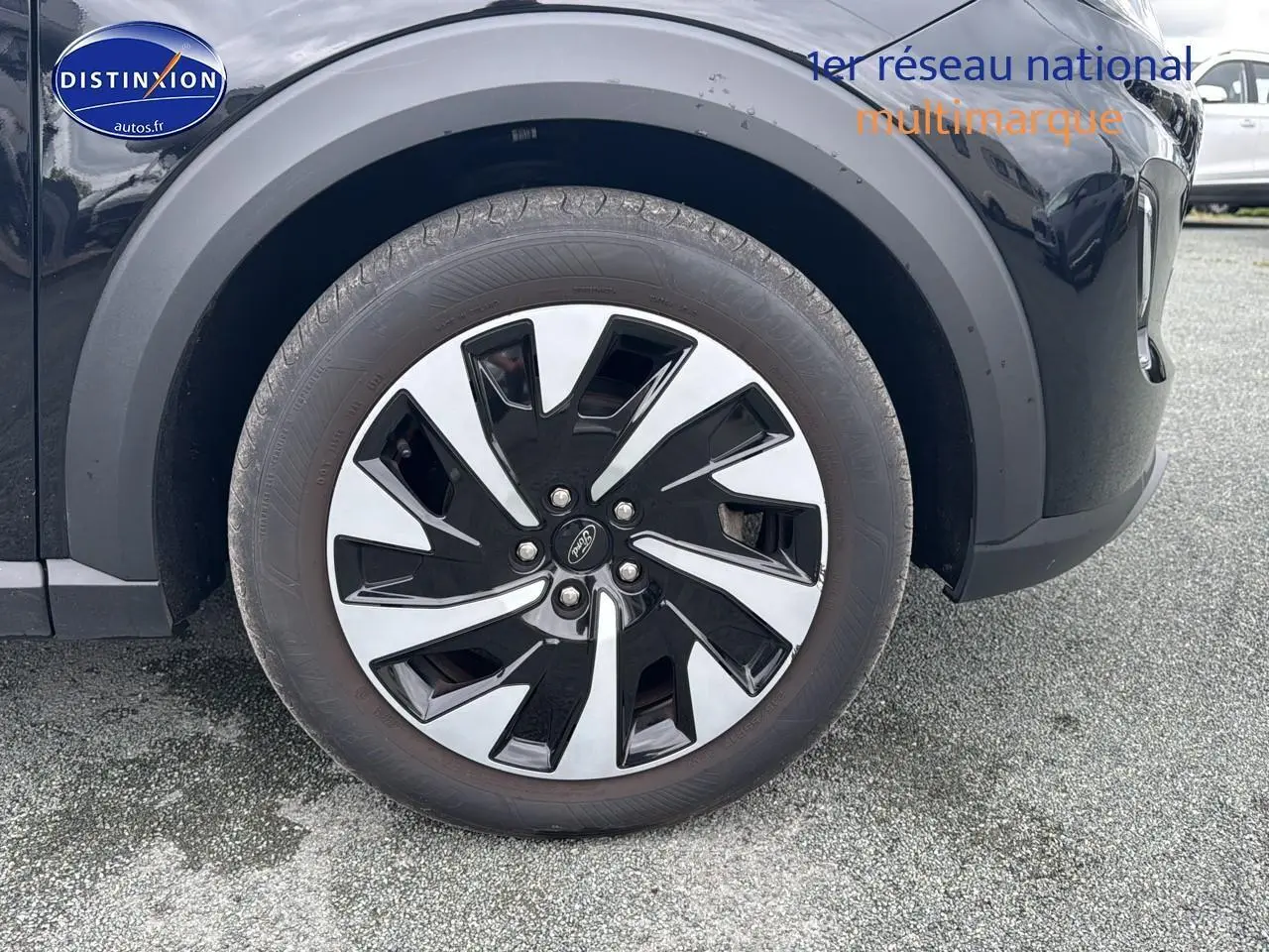 Gros plan sur la roue avant droite du Ford Puma noir 2023 avec jante alliage bicolore distinctive.