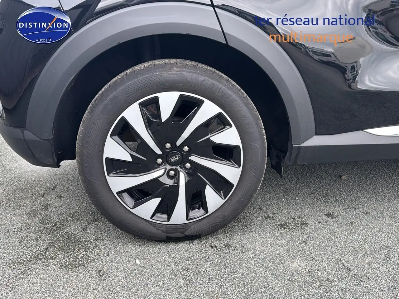 Gros plan sur la roue avant gauche noire du Ford Puma 2023 avec jante bicolore et logo Ford central.