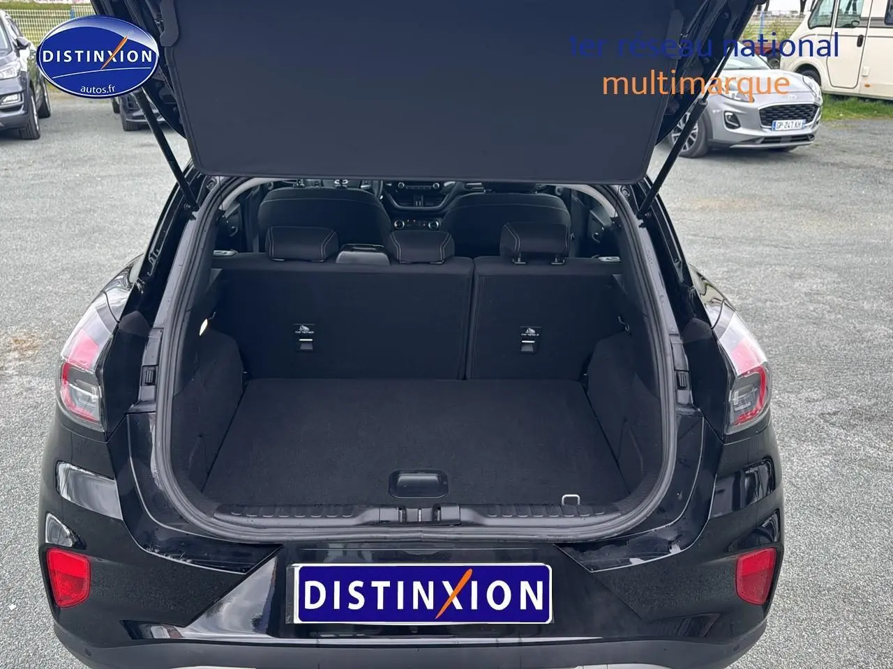 Vue arrière d'un Ford Puma noir 2023 avec coffre ouvert et banquette rabattable visible.
