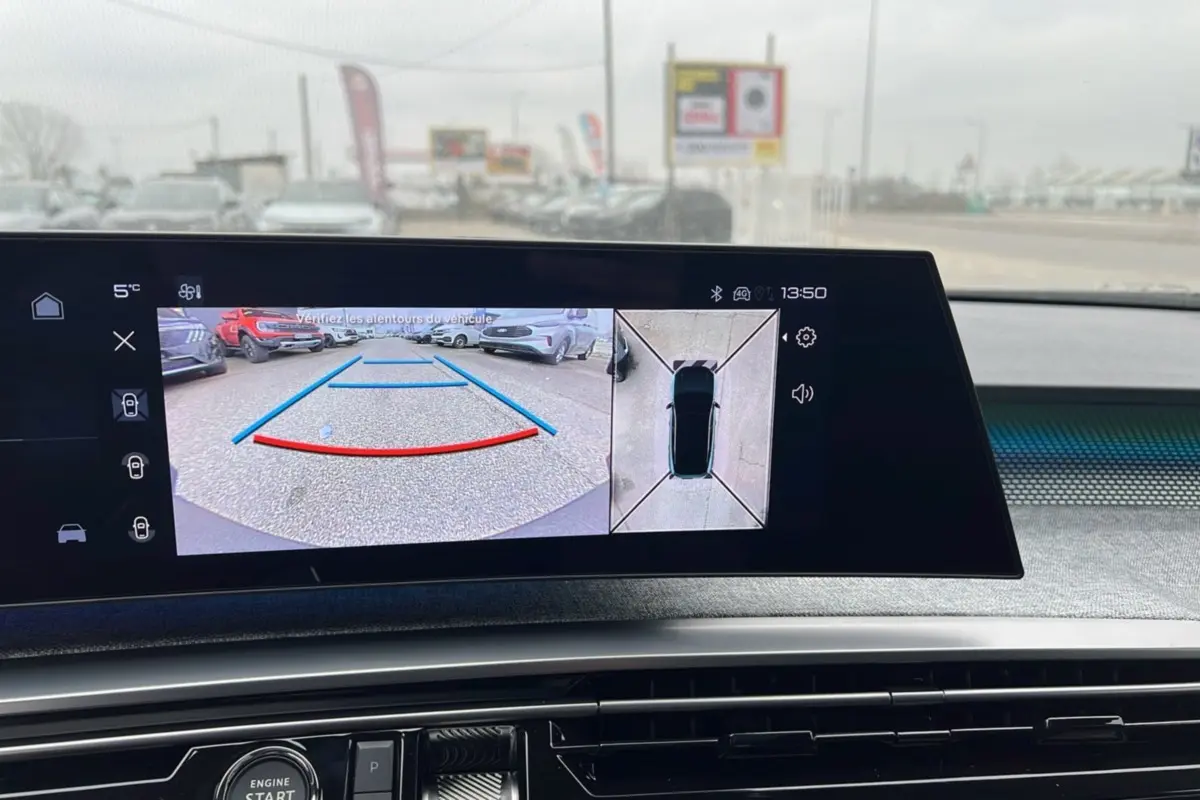 Écran intérieur affichant la caméra de recul et vue 360° du Peugeot 5008 Hybrid gris artense avec toit noir.