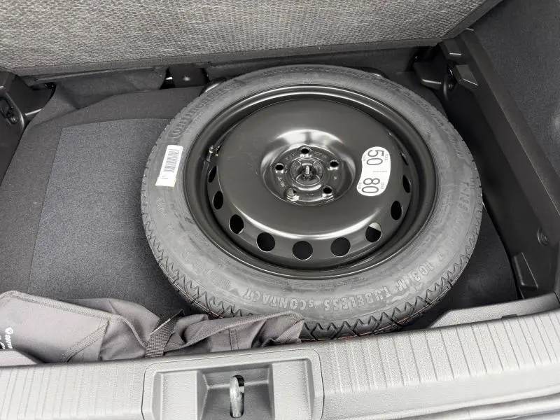 Vue rapprochée de la roue de secours noire dans le coffre du Renault Captur 2026 Gris Rafale/Noir Etoilé.