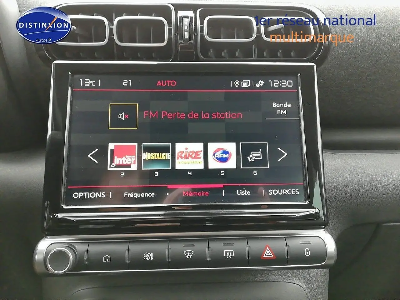 Écran tactile central de la Citroën C3 Aircross blanc polar, affichant les stations radio FM avec commandes climatisation en dessous.