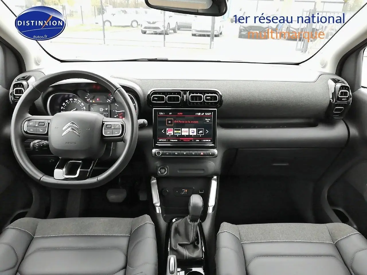 Vue intérieure frontale du tableau de bord et volant noir du Citroën C3 Aircross 2022 avec écran tactile central allumé.