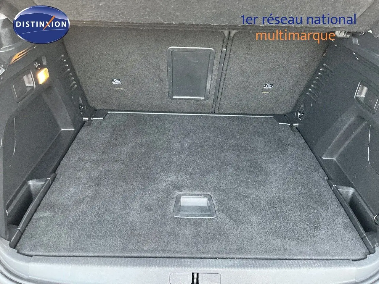 Coffre spacieux du Peugeot 3008 Cooper Metal vu de l'arrière, avec tapis de sol noir et éclairage intérieur allumé.