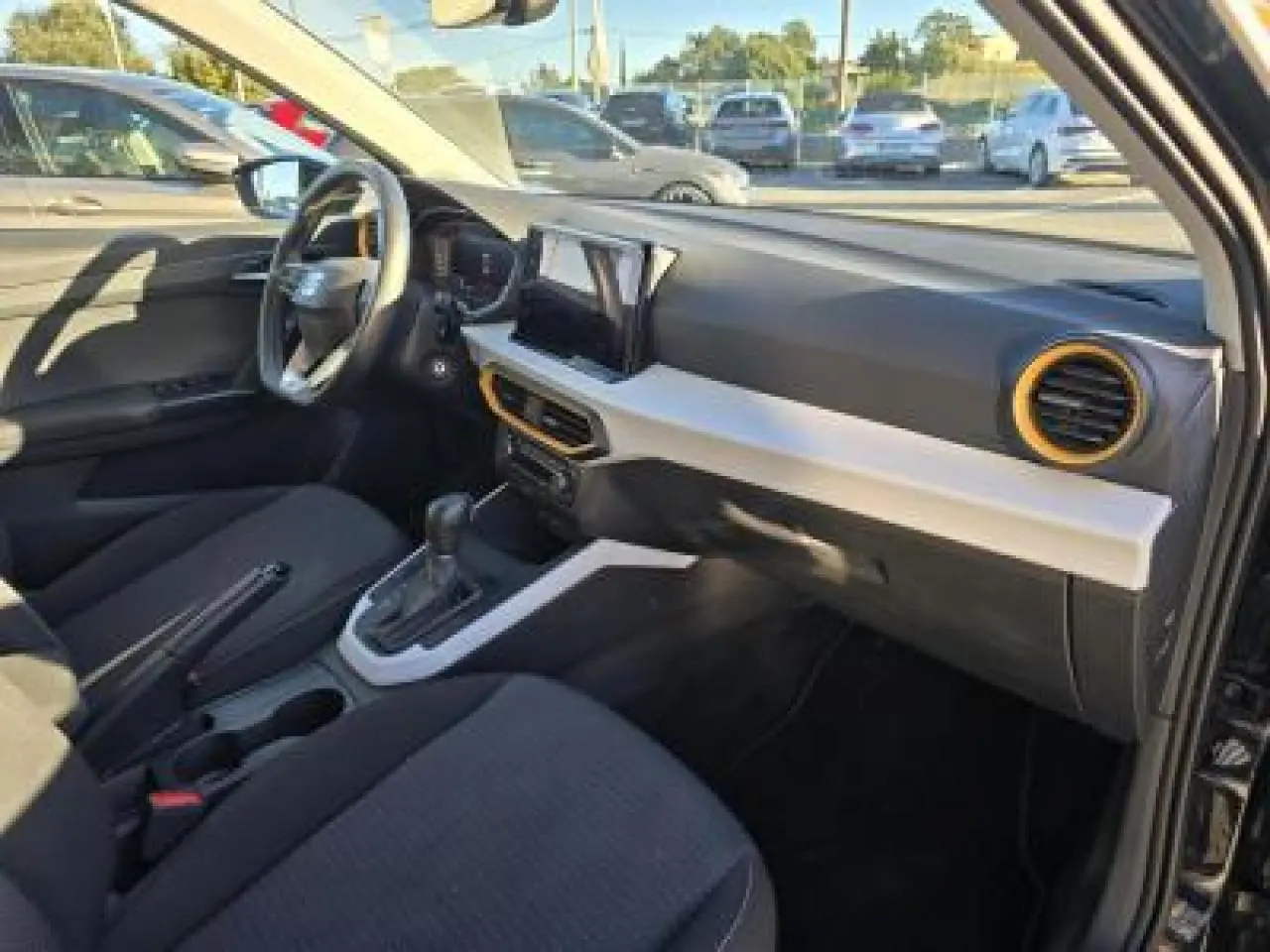 Intérieur avant droit du SEAT Arona 2024 noir minuit, avec tableau de bord bicolore et aérateurs orange.