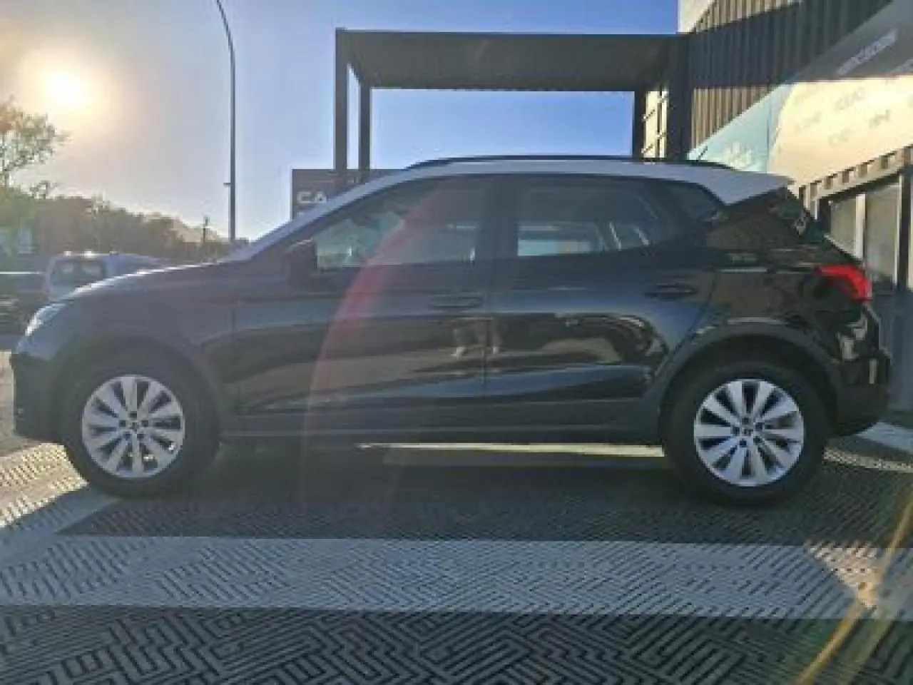 SEAT Arona noir minuit avec toit contrasté, vue de profil côté gauche en extérieur au soleil couchant.