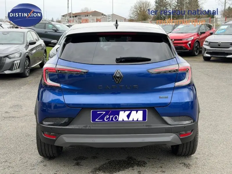 Vue arrière d’un Renault Captur 2026 hybride bleu Iron avec toit noir étoilé et feux arrière LED distinctifs.