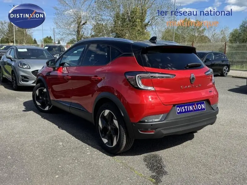Vue 3/4 arrière droite d'un Renault Captur 2025 rouge flamme avec toit noir et feux arrière LED distinctifs.