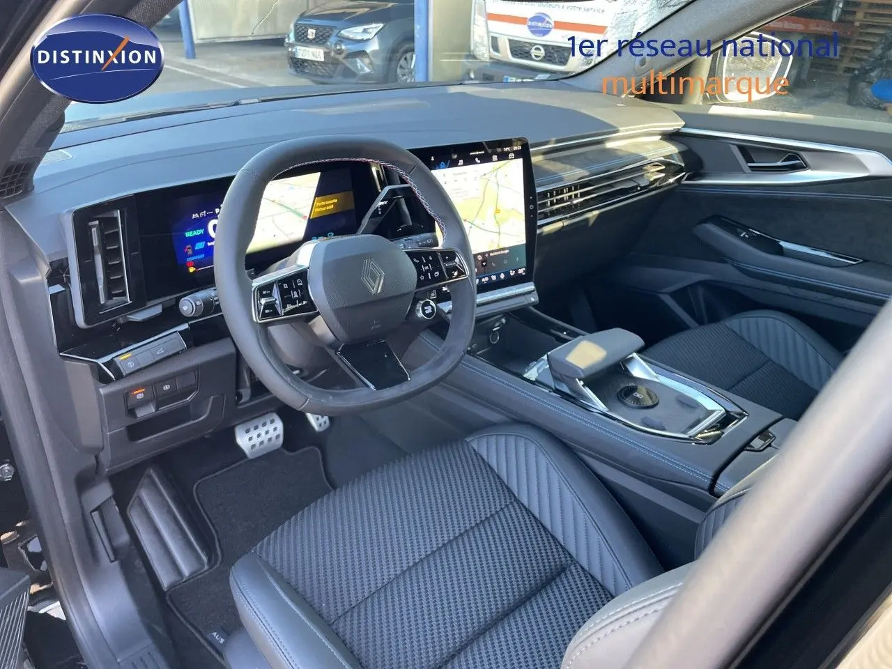 Vue intérieure côté conducteur du Renault Austral E-Tech Full Hybrid 2026, tableau de bord numérique et sièges cuir gris noir.