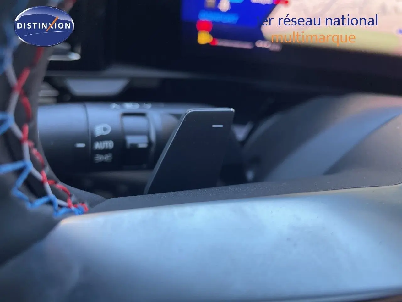 Détail intérieur du volant avec surpiqûres tricolores et commande de feux sur Renault Austral noir étoile métal.