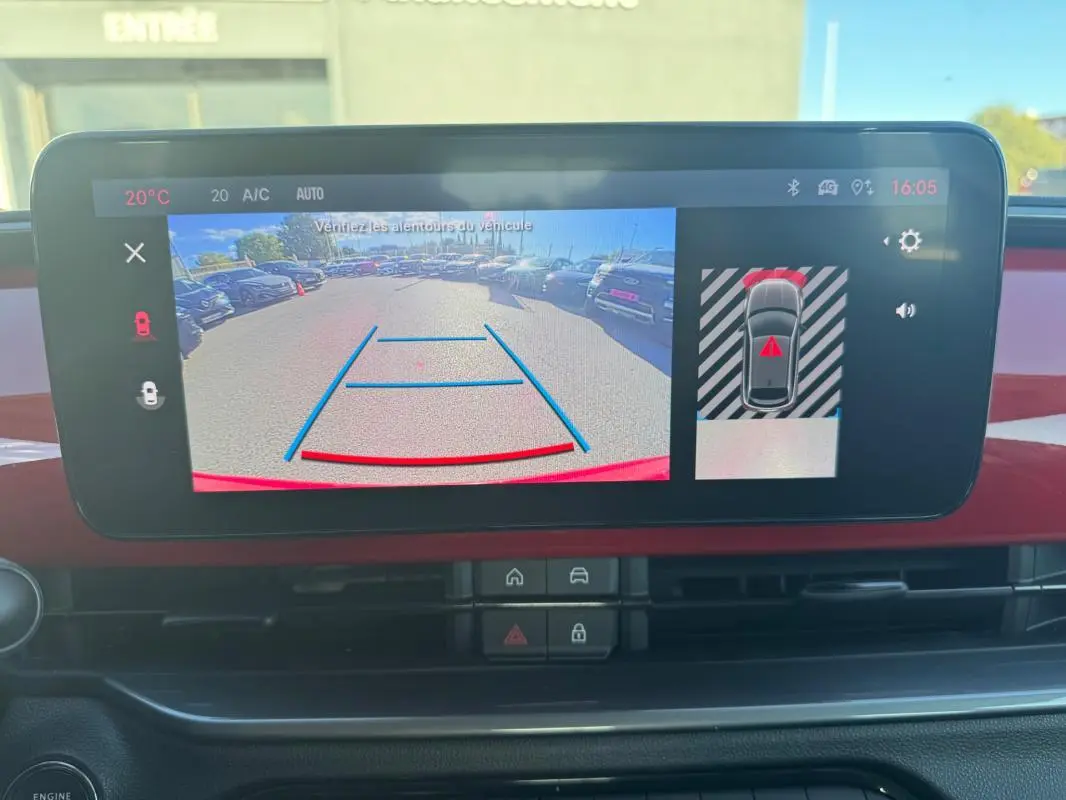 Écran central du tableau de bord du Fiat 600 T-Gen 3 rouge montrant la caméra de recul avec guidage de trajectoire.