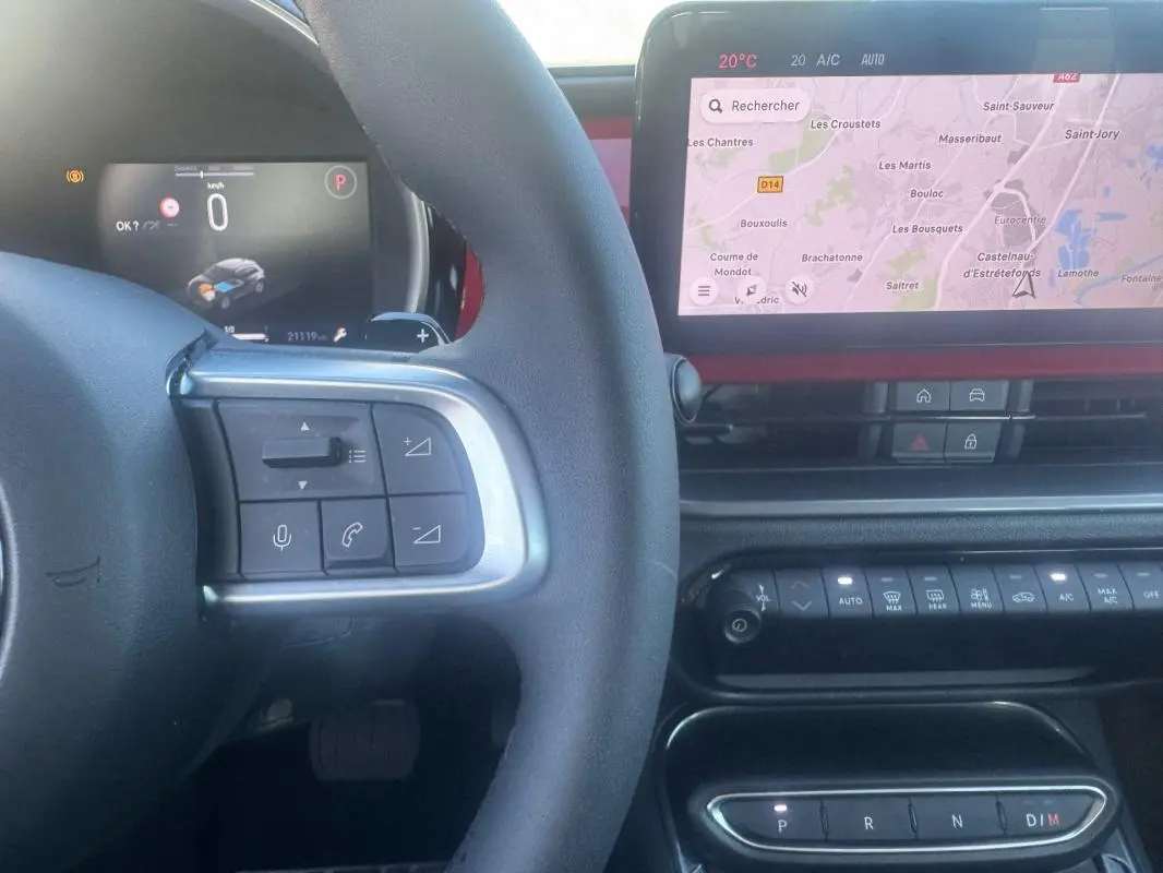 Vue intérieure centrée sur le volant et l’écran tactile du tableau de bord de la Fiat 600 rouge T-Gen 3 2025.