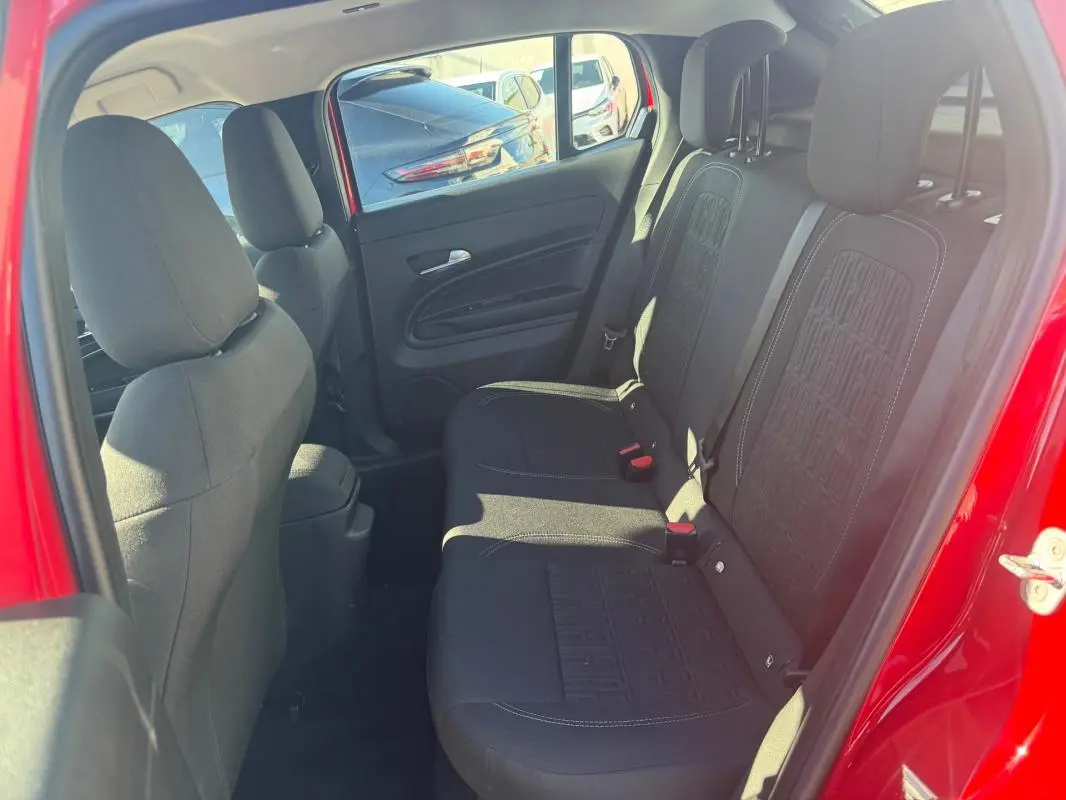 Vue intérieure arrière côté droit du Fiat 600 rouge 2025, montrant les sièges arrière en tissu noir avec motifs distinctifs.