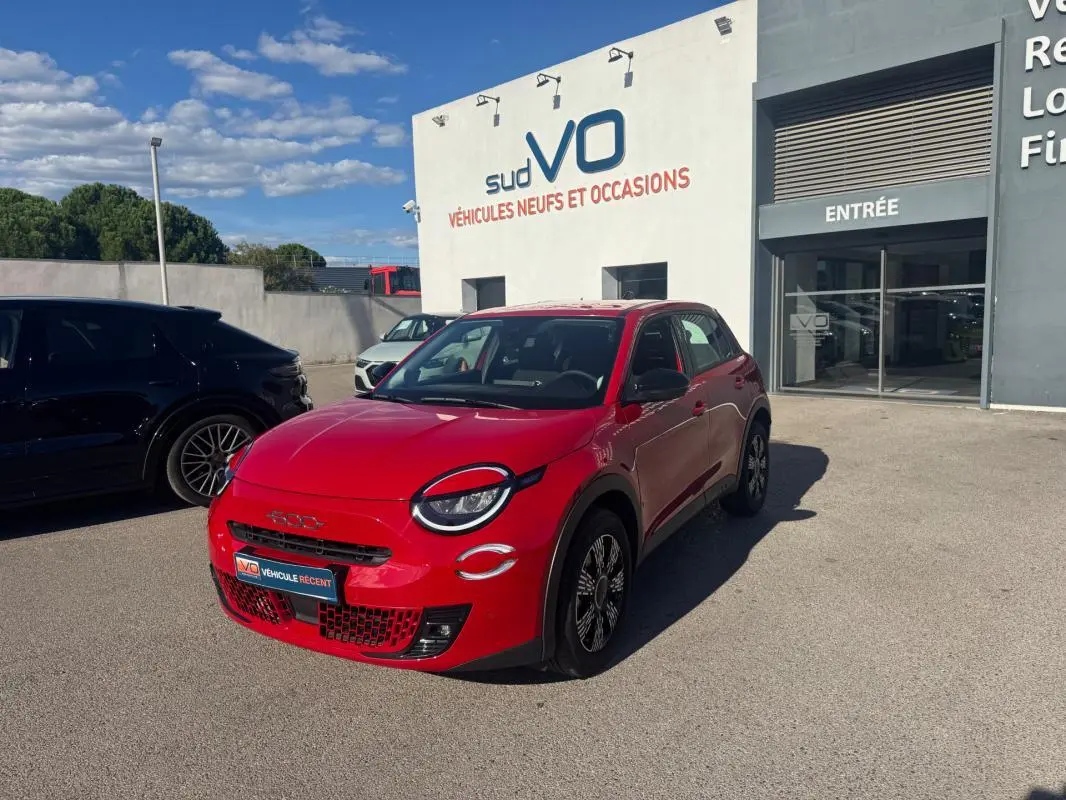 Vue 3/4 avant droite d'une FIAT 600 T-Gen 3 rouge 2025, avec phares ronds et jantes noires distinctives.