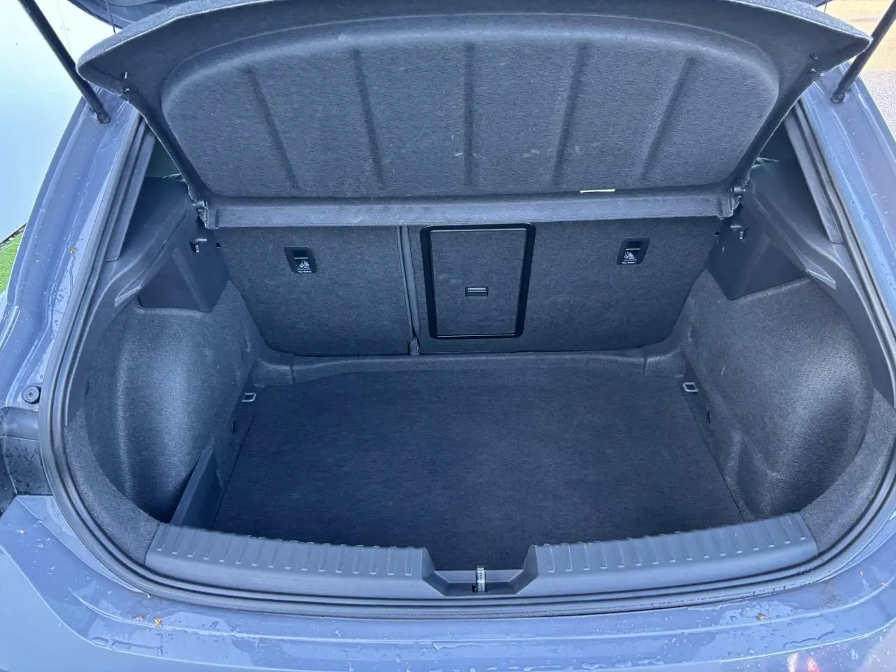 Coffre ouvert vu de l'arrière d'une CUPRA Leon 2024 gris Graphene, montrant un espace de chargement propre et spacieux.