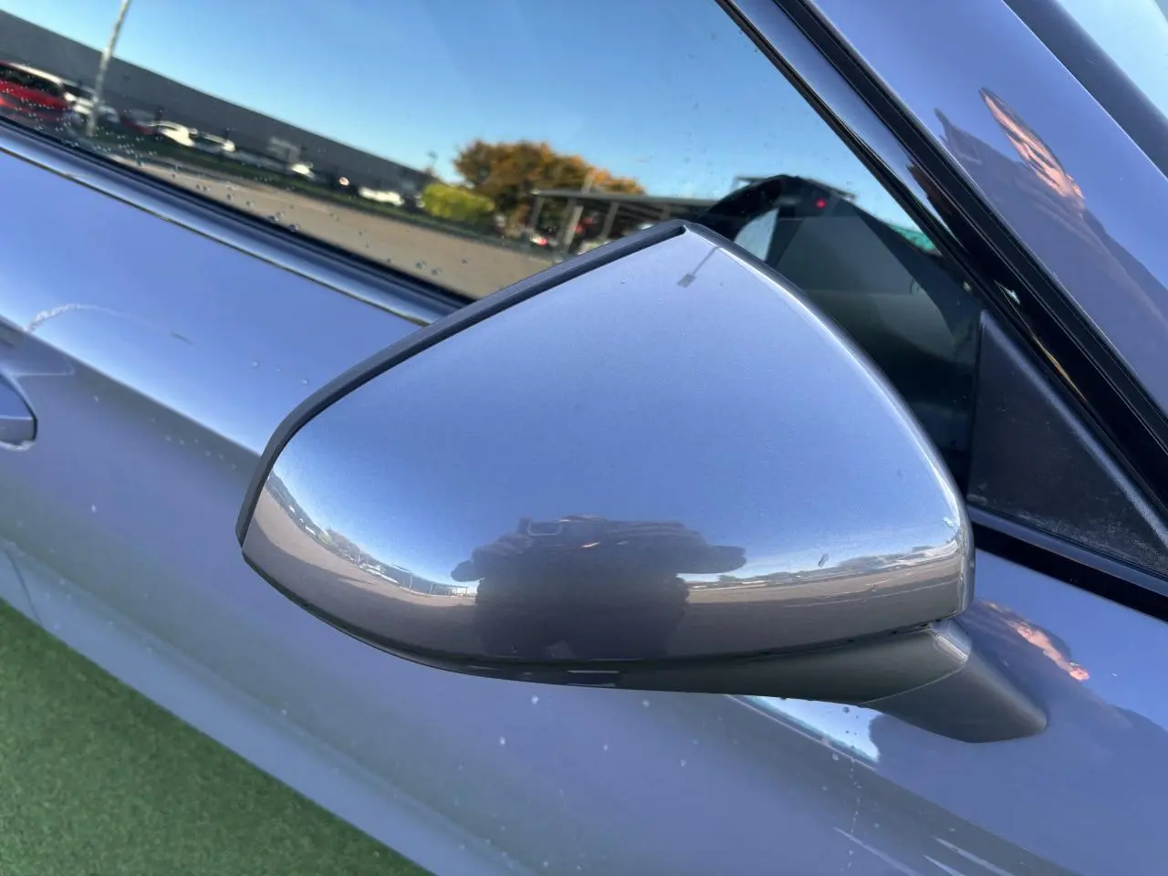 Rétroviseur côté gauche gris Graphene de la CUPRA Leon 2024, avec reflet et partie de la portière visible.