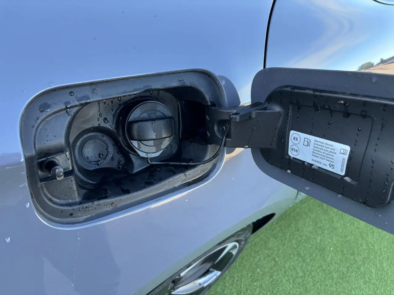 Gros plan sur la trappe à carburant côté gauche d'une CUPRA Leon gris Graphene avec bouchon essence ouvert.