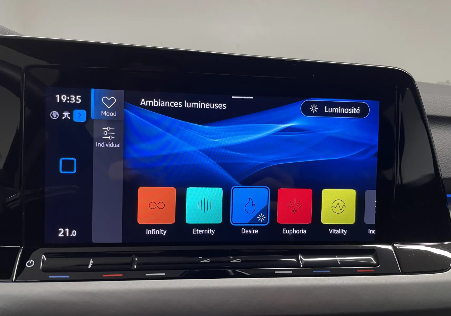 Écran tactile intérieur de la Volkswagen Golf 2023 affichant les ambiances lumineuses avec fond bleu et options colorées.