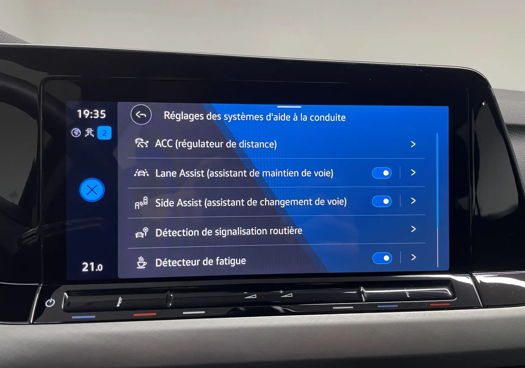 Écran tactile du tableau de bord de la Volkswagen Golf 2023 affichant les réglages des aides à la conduite.