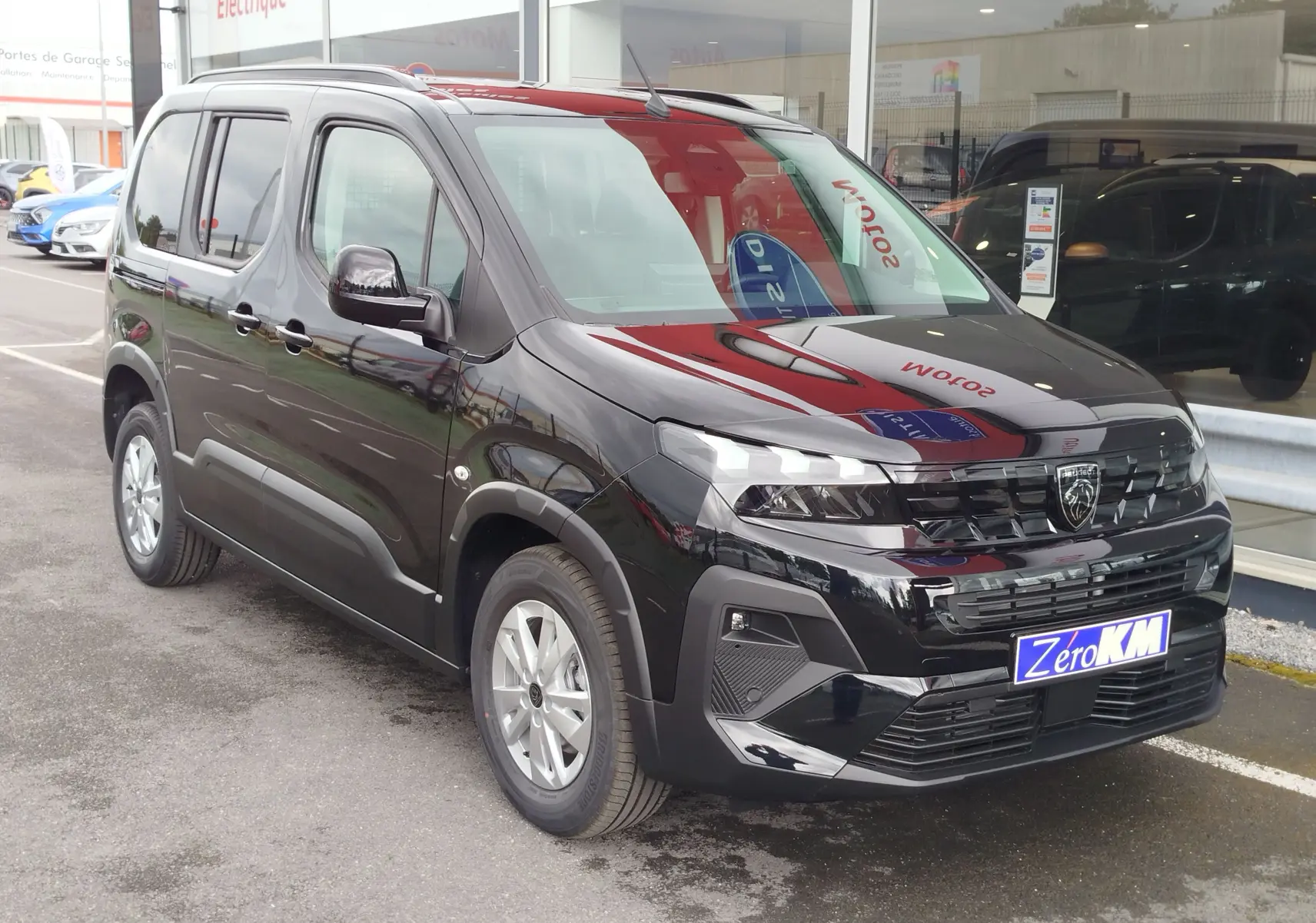 Peugeot Rifter noir Perla Nera vue 3/4 avant droit, avec calandre distinctive et jantes argentées en concession.