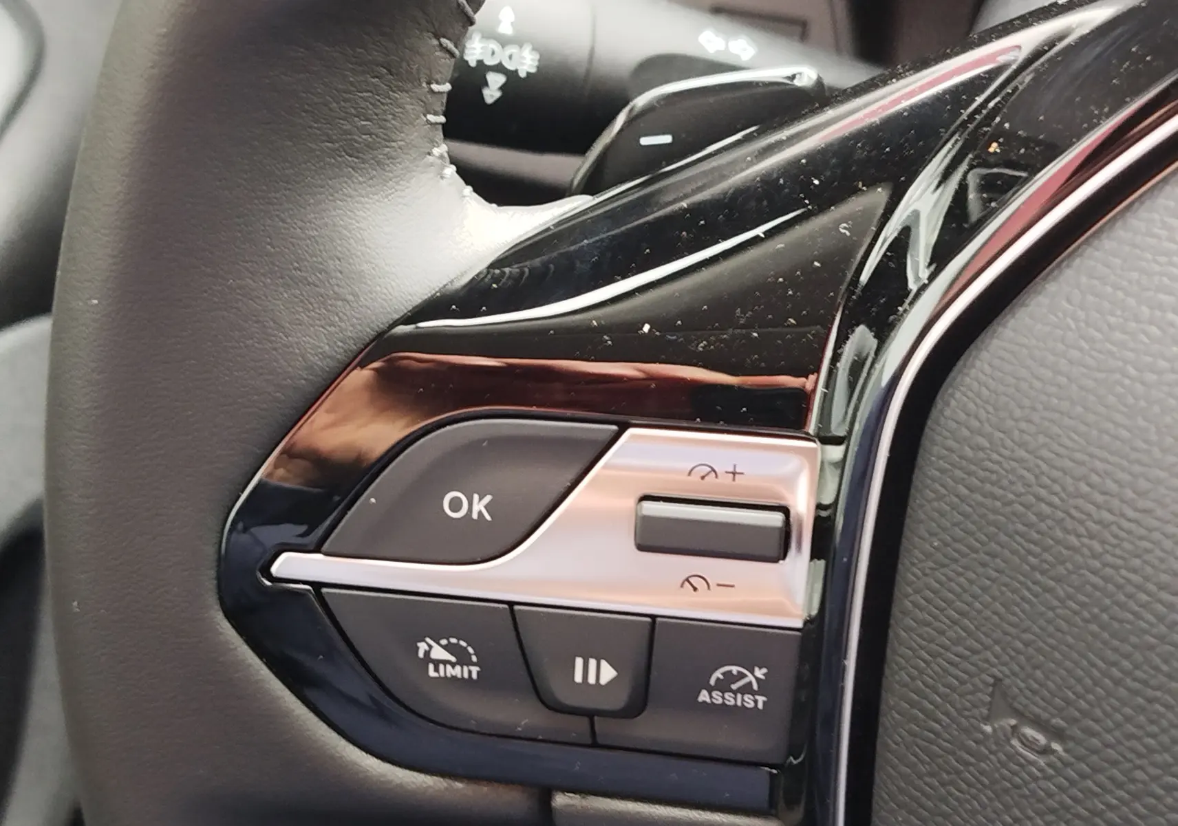 Détail du côté gauche du volant noir du Peugeot Rifter 2026, boutons de commande du régulateur et limiteur de vitesse.