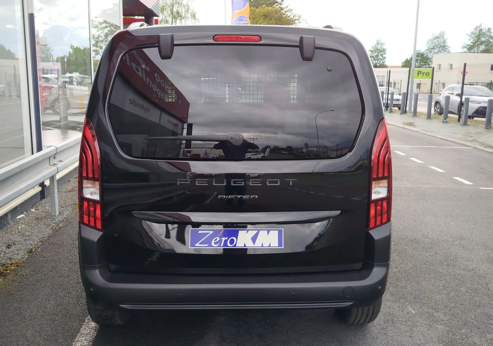 Vue arrière du Peugeot Rifter noir Perla Nera 2026 avec feux arrière verticaux et vitre arrière teintée.