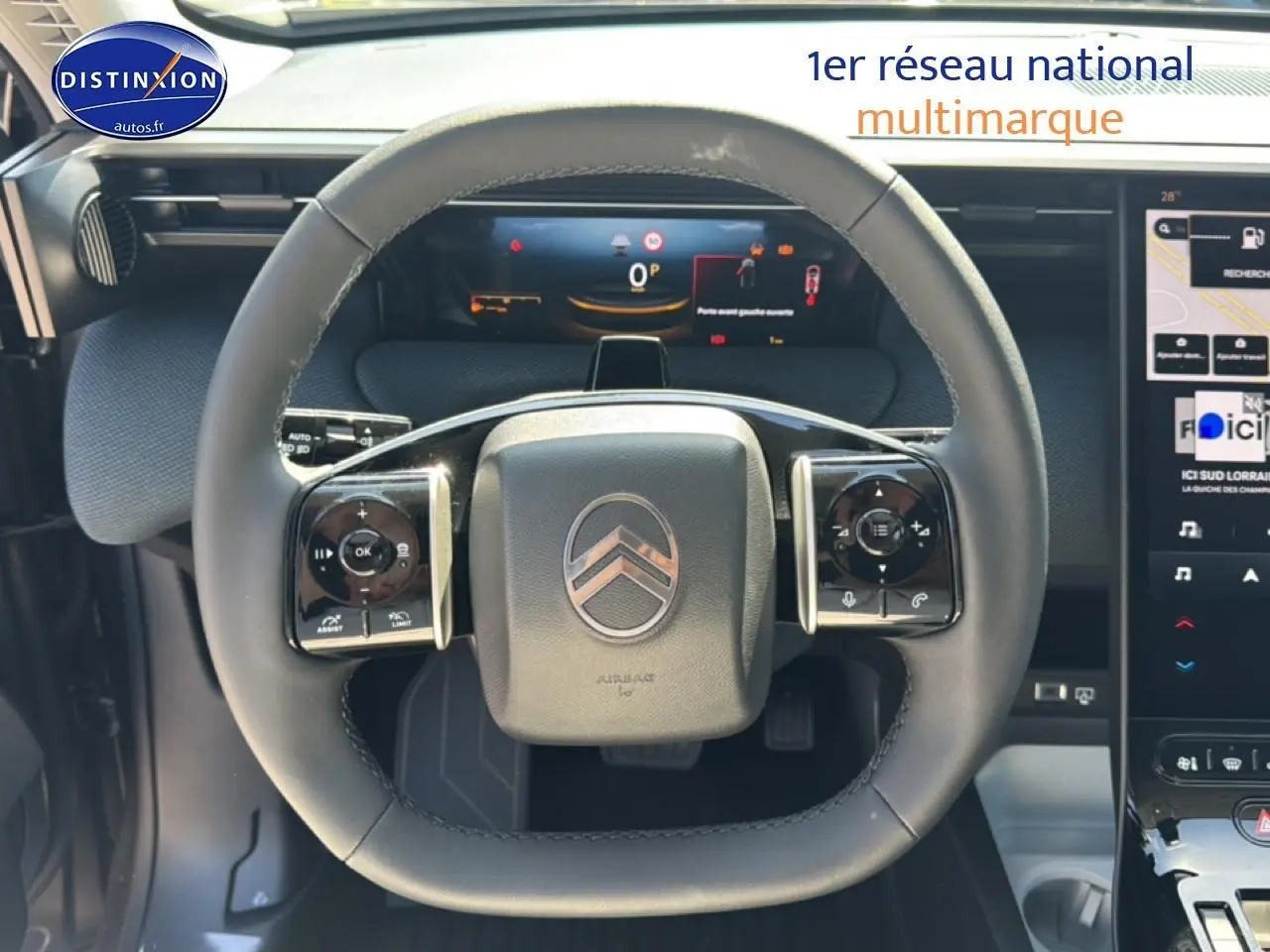Vue rapprochée du volant multifonction noir du Citroën C5 Aircross 2026 avec tableau de bord numérique et écran tactile.