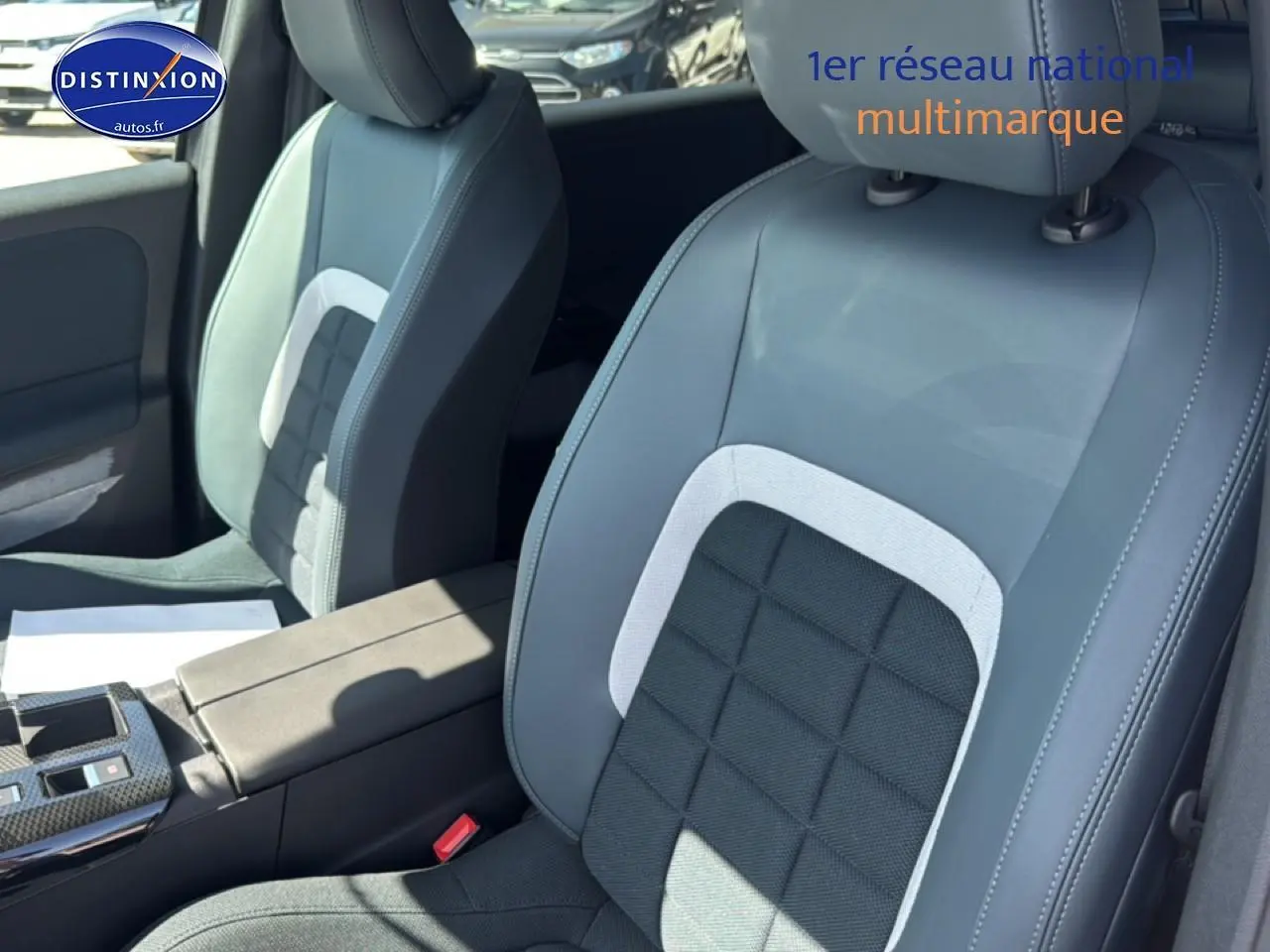 Gros plan sur les sièges avant gris clair et noir du Citroën C5 Aircross 2026, avec accoudoir central visible.
