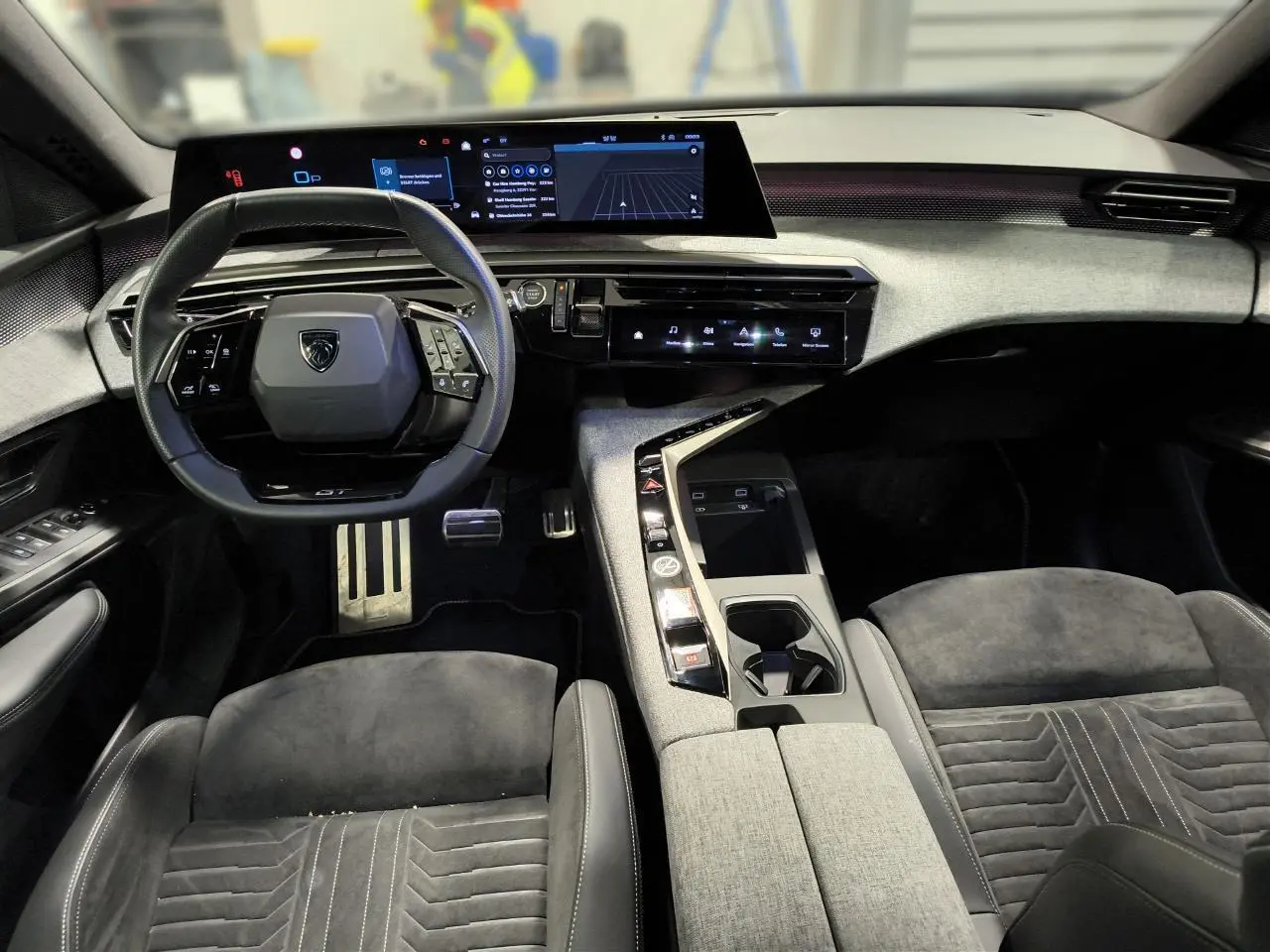 Intérieur Peugeot 3008 Hybrid 145 GT vu de face, sellerie Alcantara gris et tableau de bord numérique panoramique.