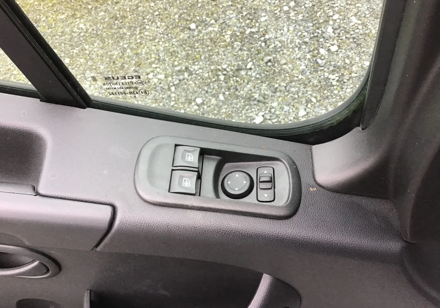 Détail des commandes électriques des vitres et des rétroviseurs sur la porte côté conducteur d’un Opel Movano blanc.
