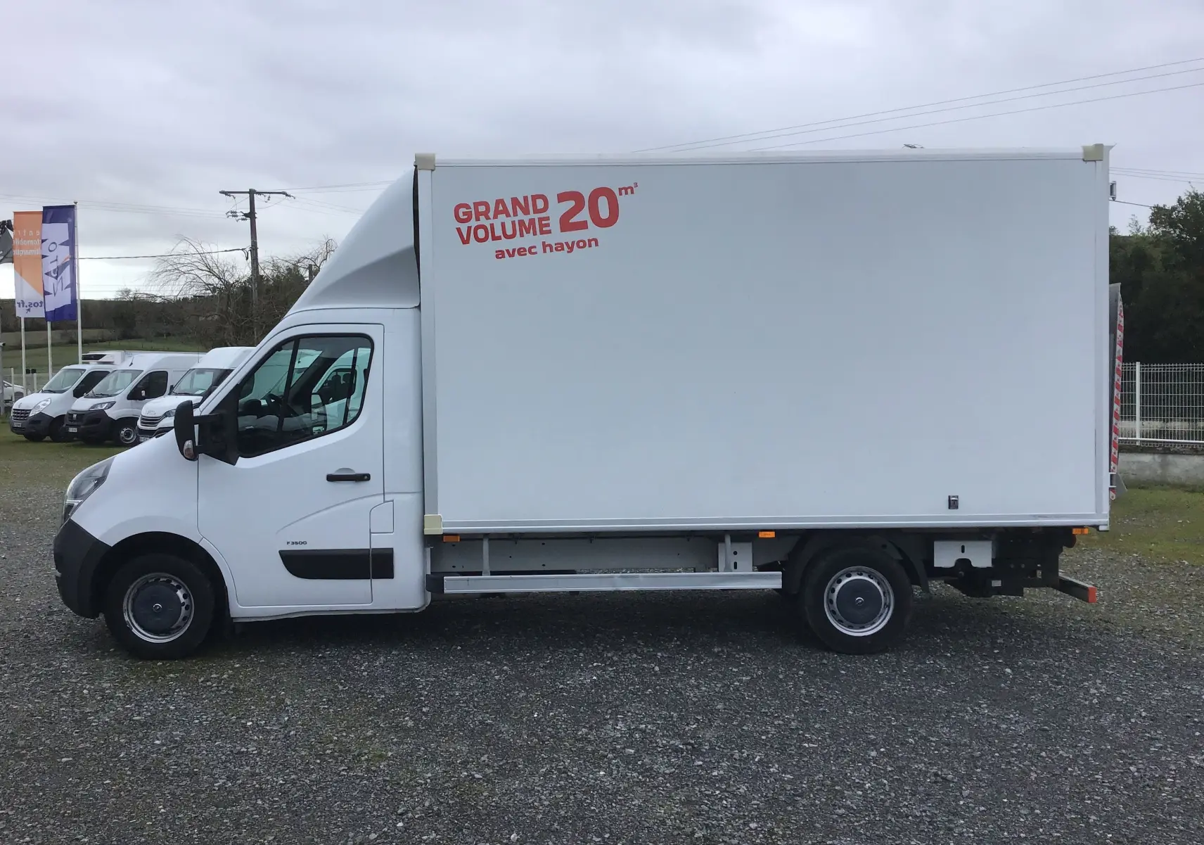 Vue de profil côté gauche d’un Opel Movano blanc avec grande caisse 20m³ et hayon électrique visible à l’arrière.