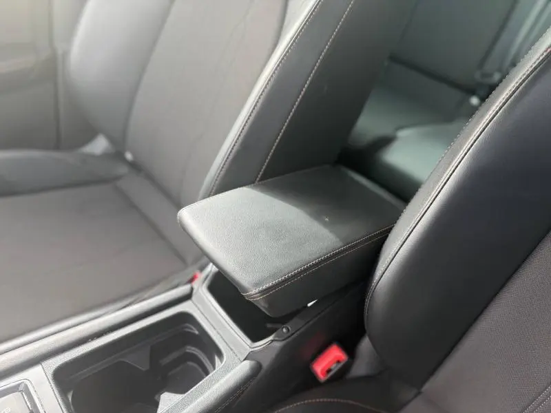 Vue rapprochée de l'accoudoir central noir en textile et TEP sur les sièges avant du CUPRA Formentor bleu 2025.