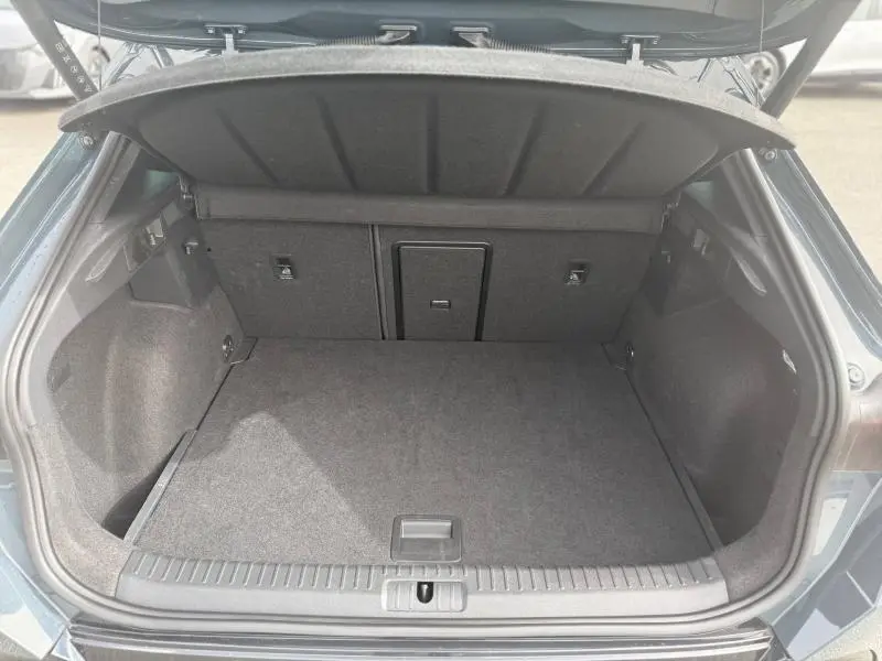 Coffre ouvert vu de l'arrière d'un CUPRA Formentor bleu, montrant un espace de chargement propre et bien fini.