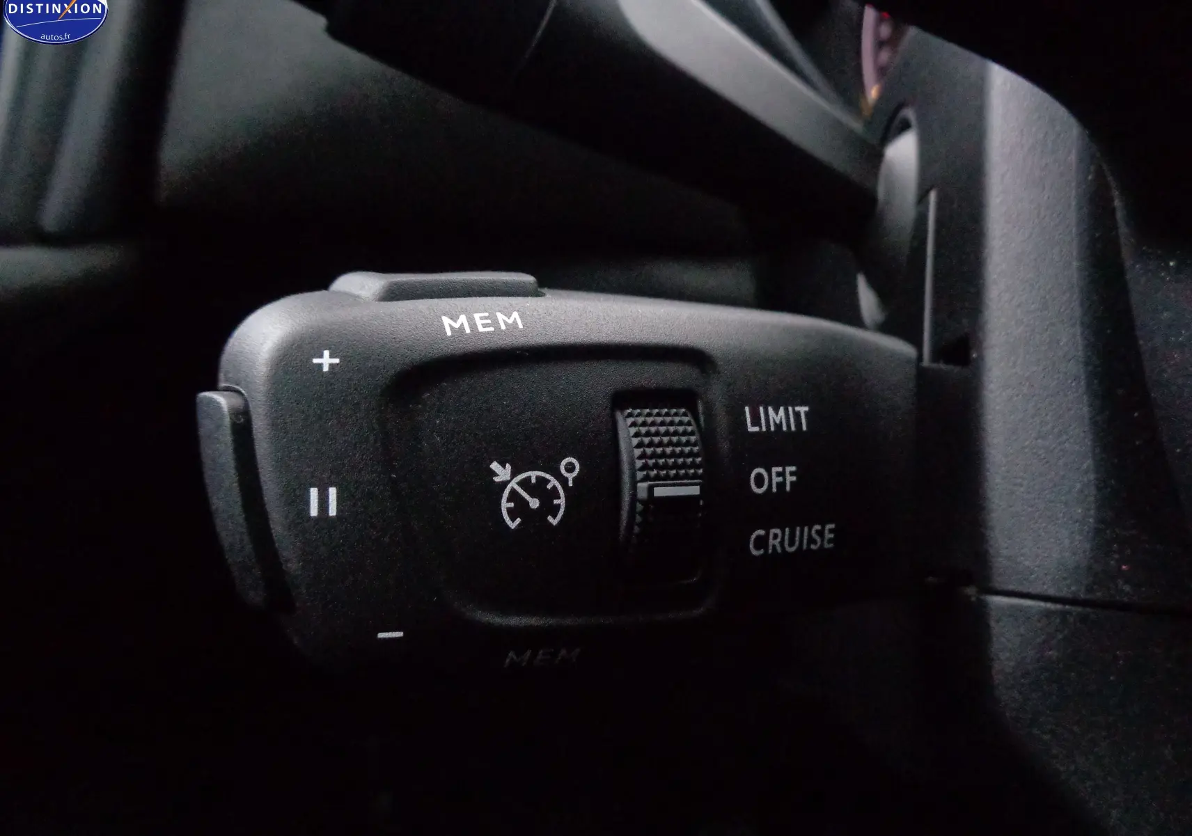 Gros plan sur la commande de régulateur de vitesse à gauche du volant dans le DS3 Crossback gris Artense Metal.