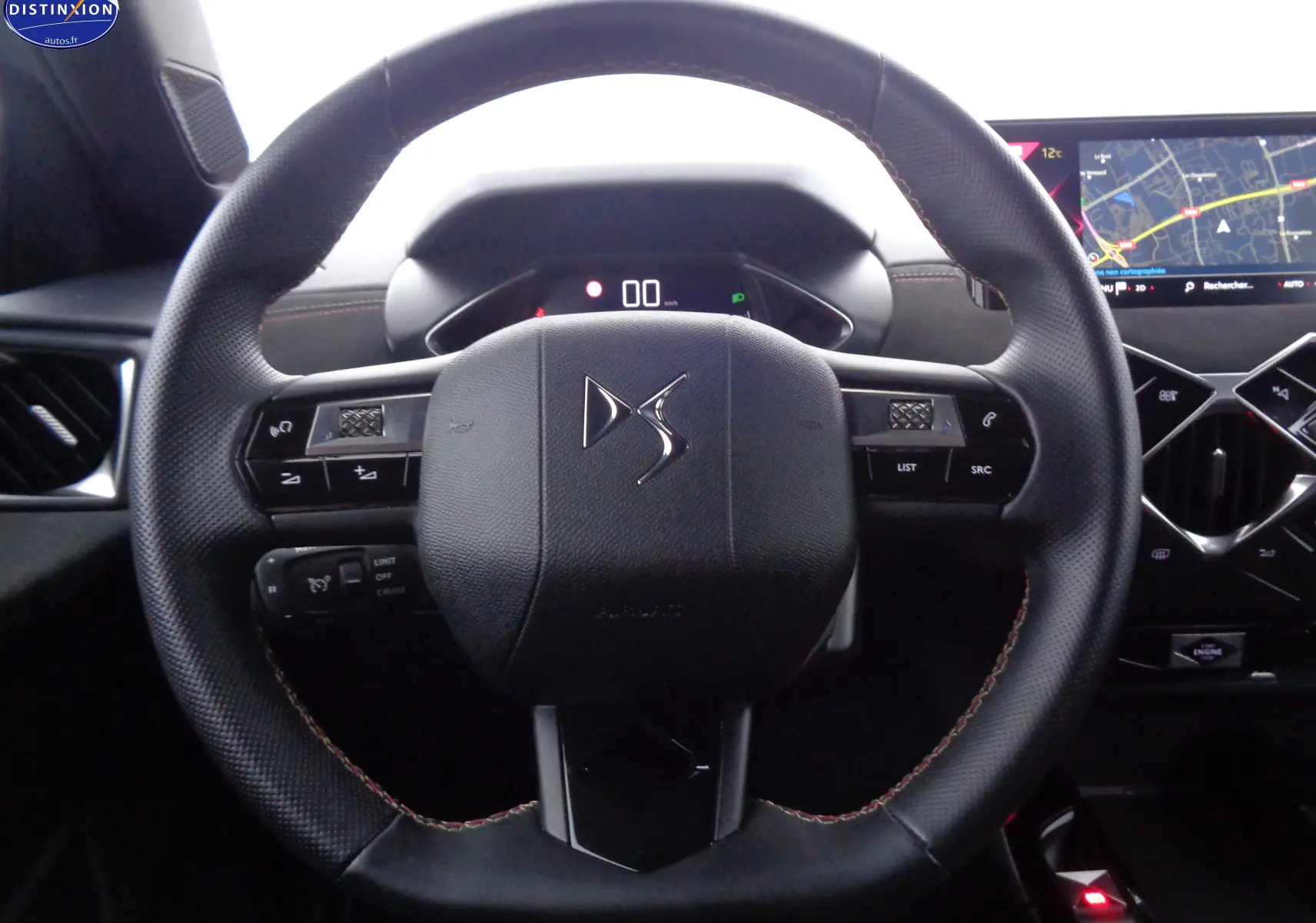 Volant en cuir noir avec logo DS au centre, tableau de bord numérique et écran tactile de navigation à droite.