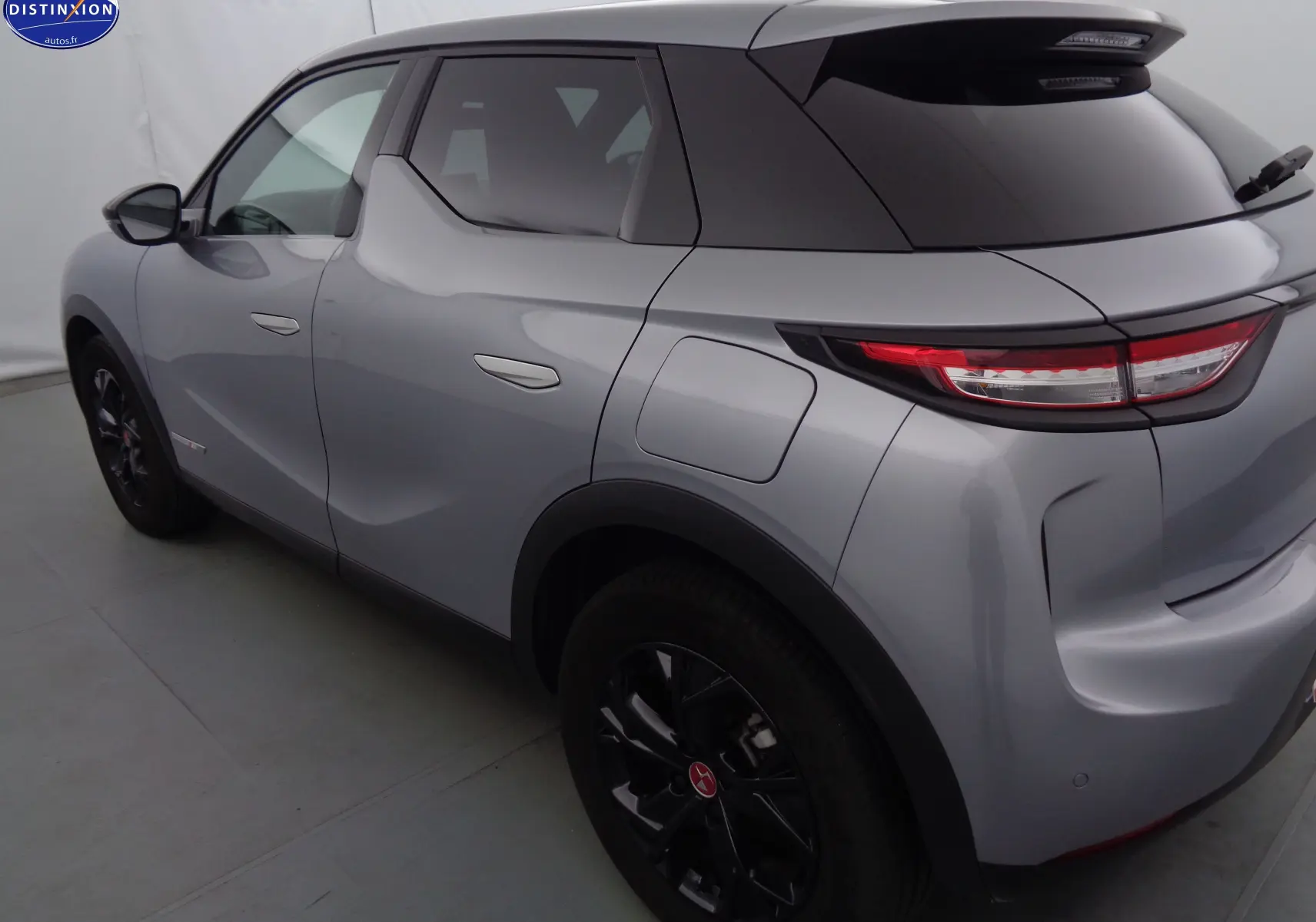 Vue côté droit arrière d'un DS3 Crossback gris Artense métallisé avec jantes noires et vitres teintées.