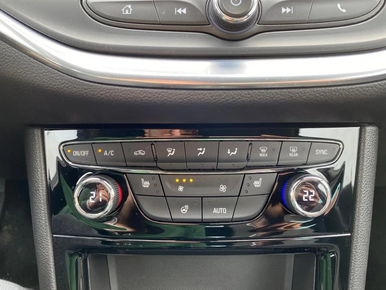 Panneau de commande de climatisation de l'Opel Astra 2021 avec réglages digitaux et boutons chauffants visibles.