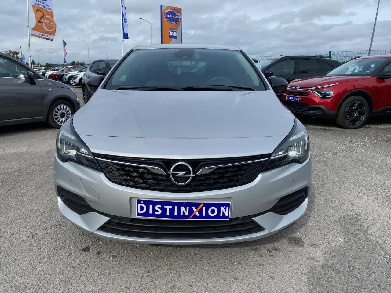 Vue frontale d'une Opel Astra Sovereign Silver 2021 avec calandre noire et phares modernes, stationnée en extérieur.