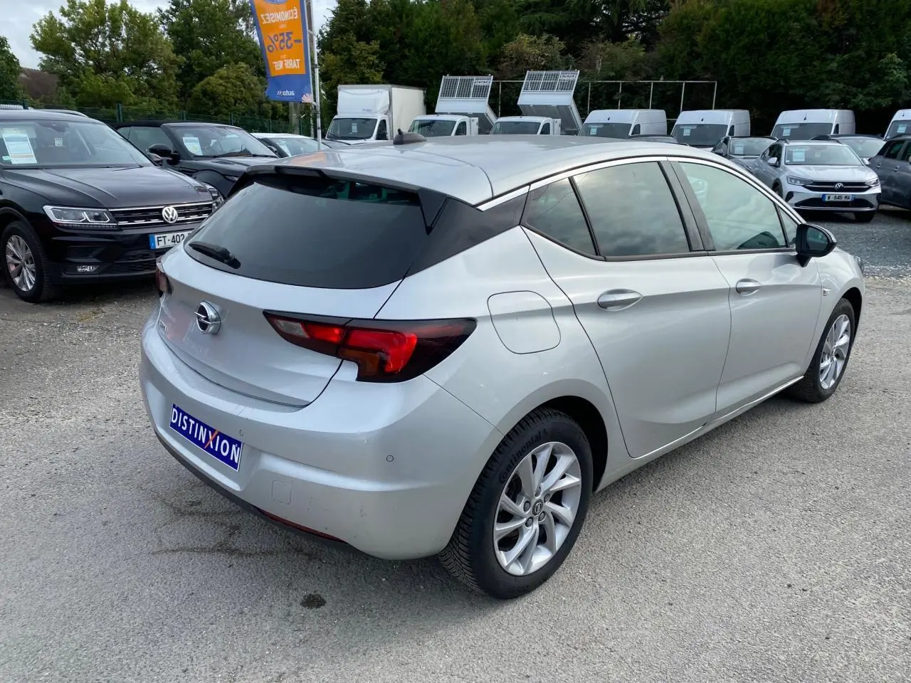 Opel Astra 2021 couleur argent Sovereign Silver vue 3/4 arrière droit avec vitres surteintées et jantes alliage 16 pouces.
