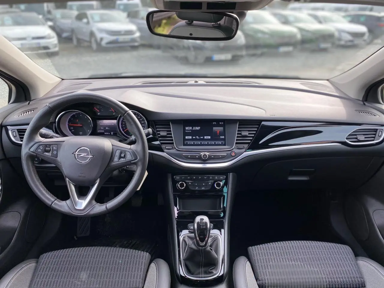 Intérieur de l'Opel Astra 2021 vu de face, tableau de bord noir avec écran tactile et volant multifonction.