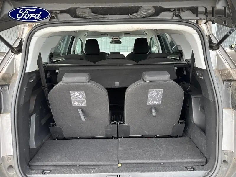 Vue arrière du coffre du Peugeot 5008 gris Artense avec deux sièges arrière supplémentaires relevés et banquette rabattue.