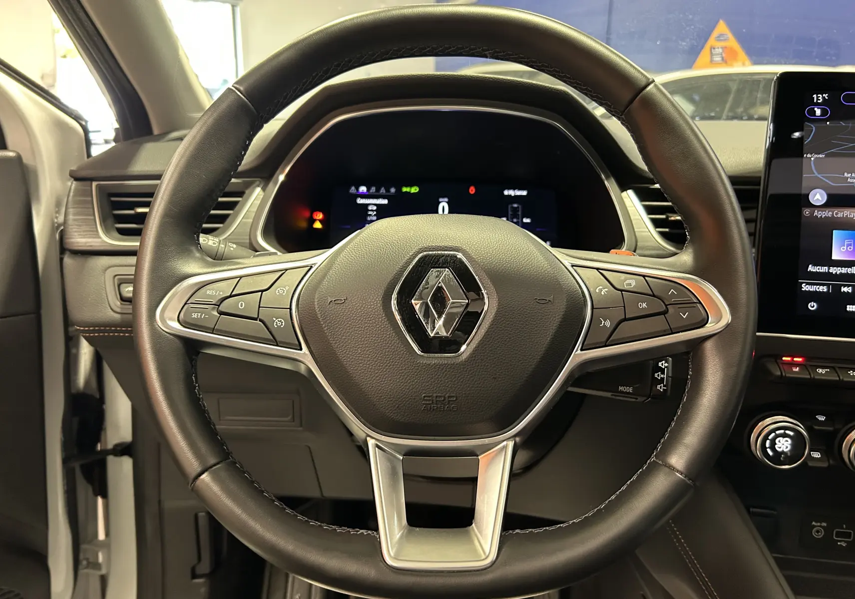 Vue rapprochée du volant cuir noir du Renault Captur II Iconic 2022 avec commandes intégrées et tableau de bord digital.